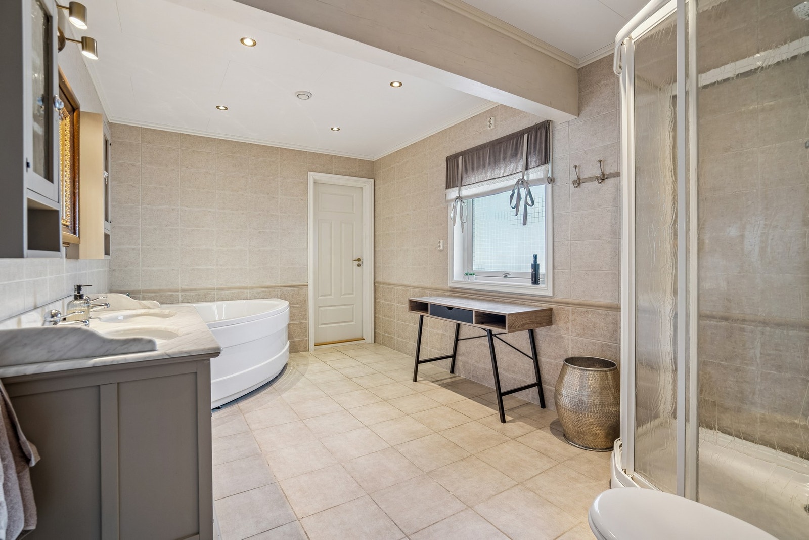 Det er hjørnebadekar, dusj og dobbel servant. Galleribilde