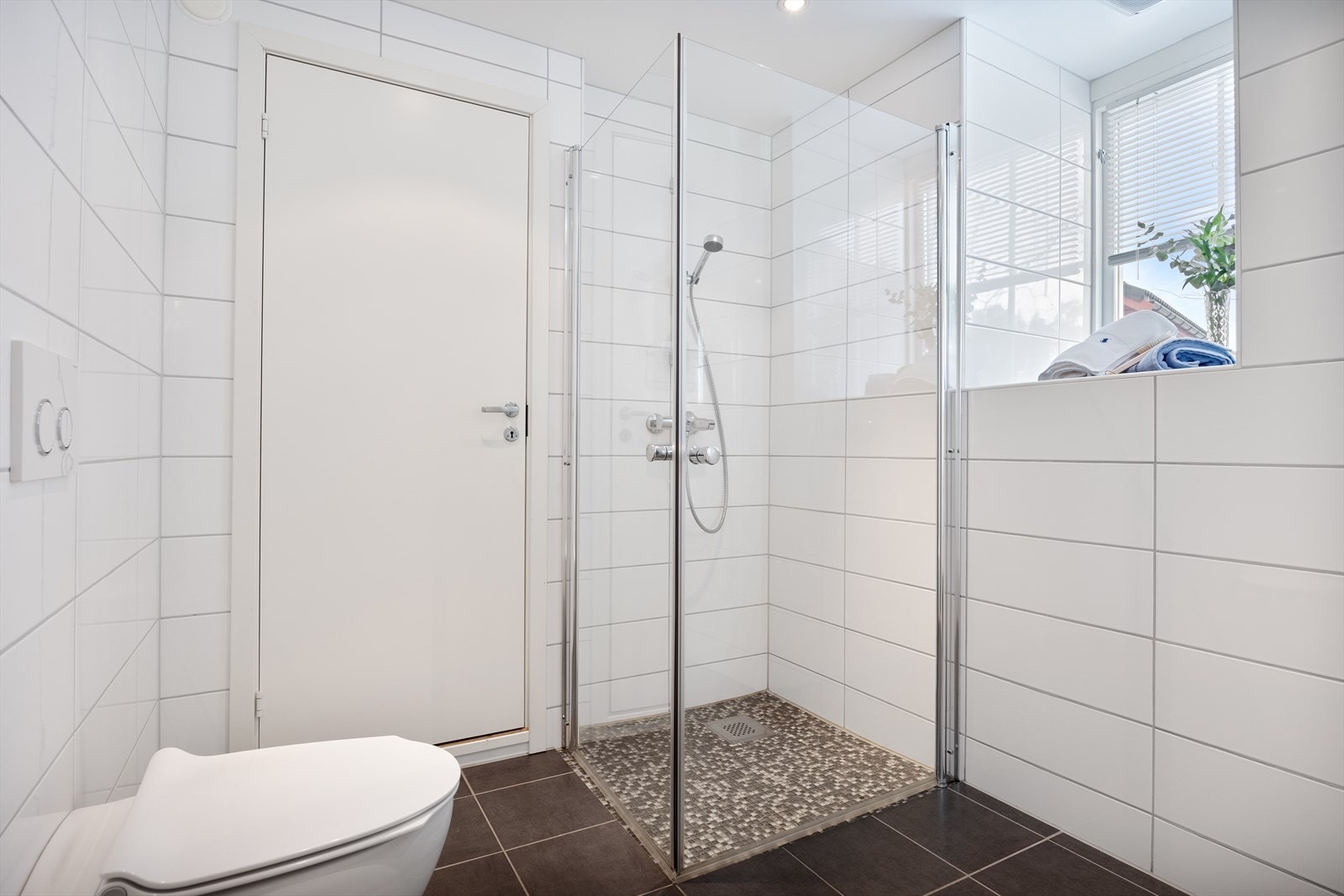 Baderom med flisbelagte overflater og dusjløsning. Galleribilde