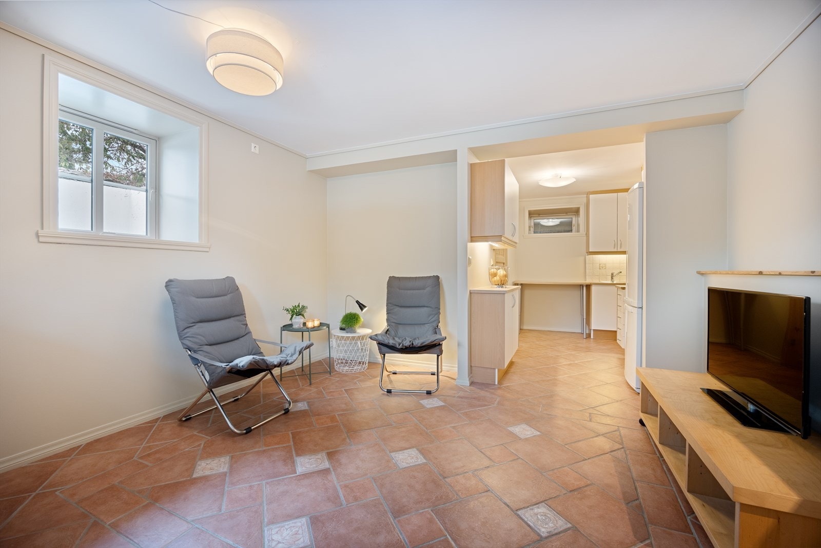 Oppholdsrom i sokkeldel med kjøkkenløsning. Galleribilde