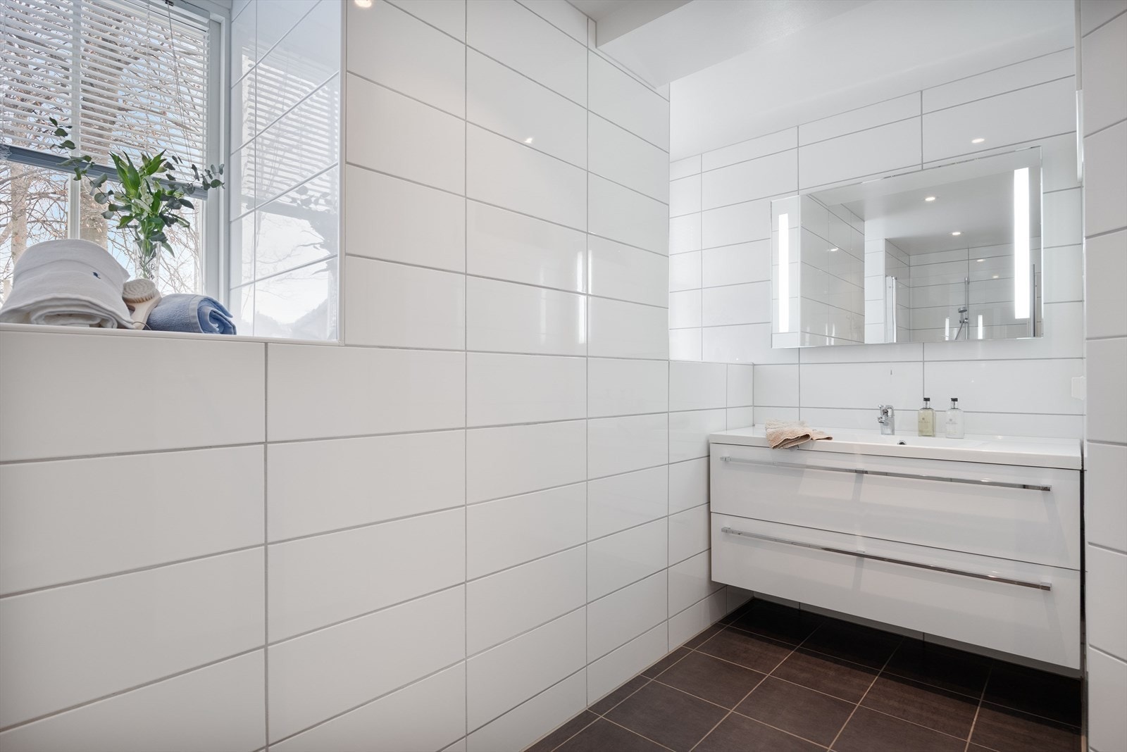 Praktisk servantinnredning med oppbevaring og vindu som gir naturlig lys og lufting. Galleribilde