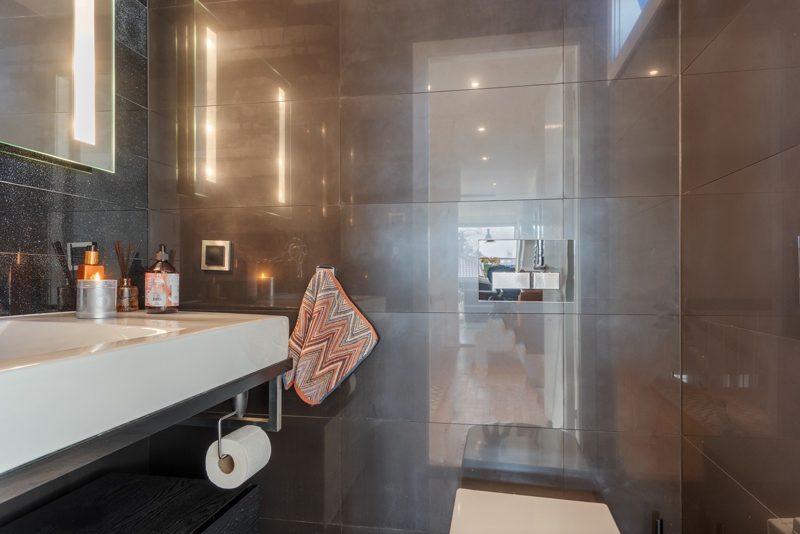 Praktisk toalettrom med stor servant og vegghengt toalett. Galleribilde