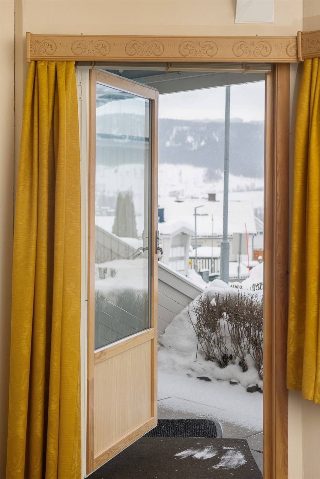 Terrassedøren åpner opp mot en hellebelagt uteplass på bakkeplan. Galleribilde