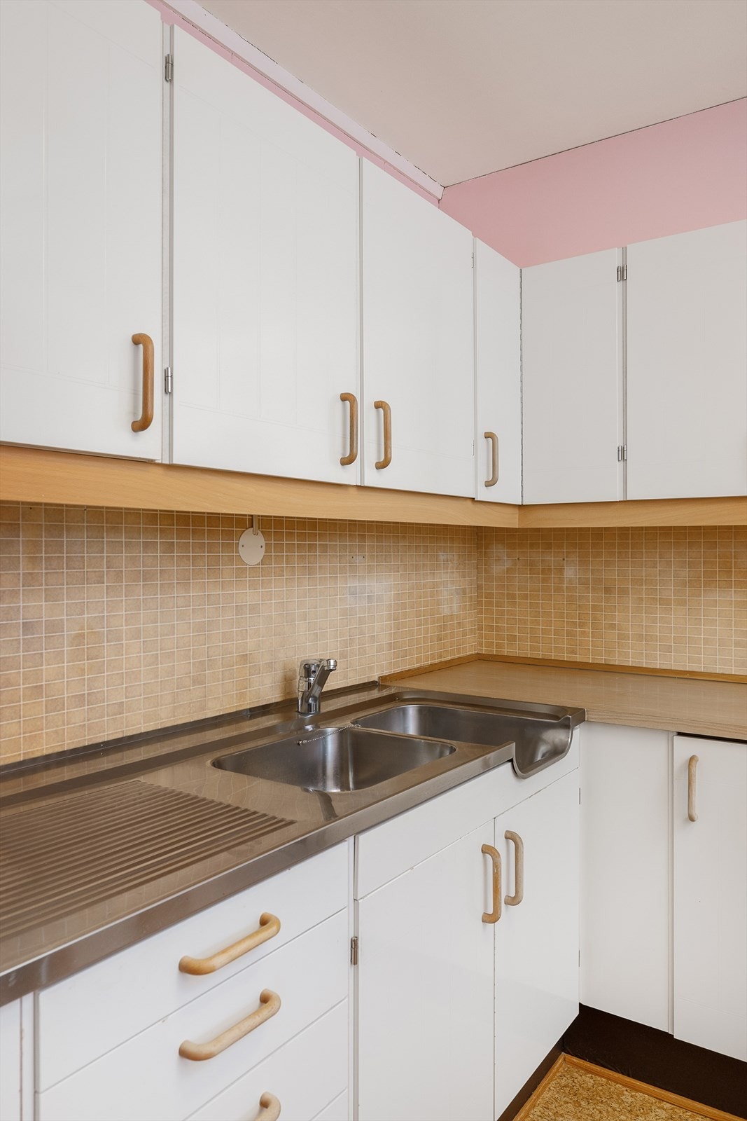 Kjøkkenbenken i laminat har en robust, dobbel oppvaskkum i stål. Galleribilde