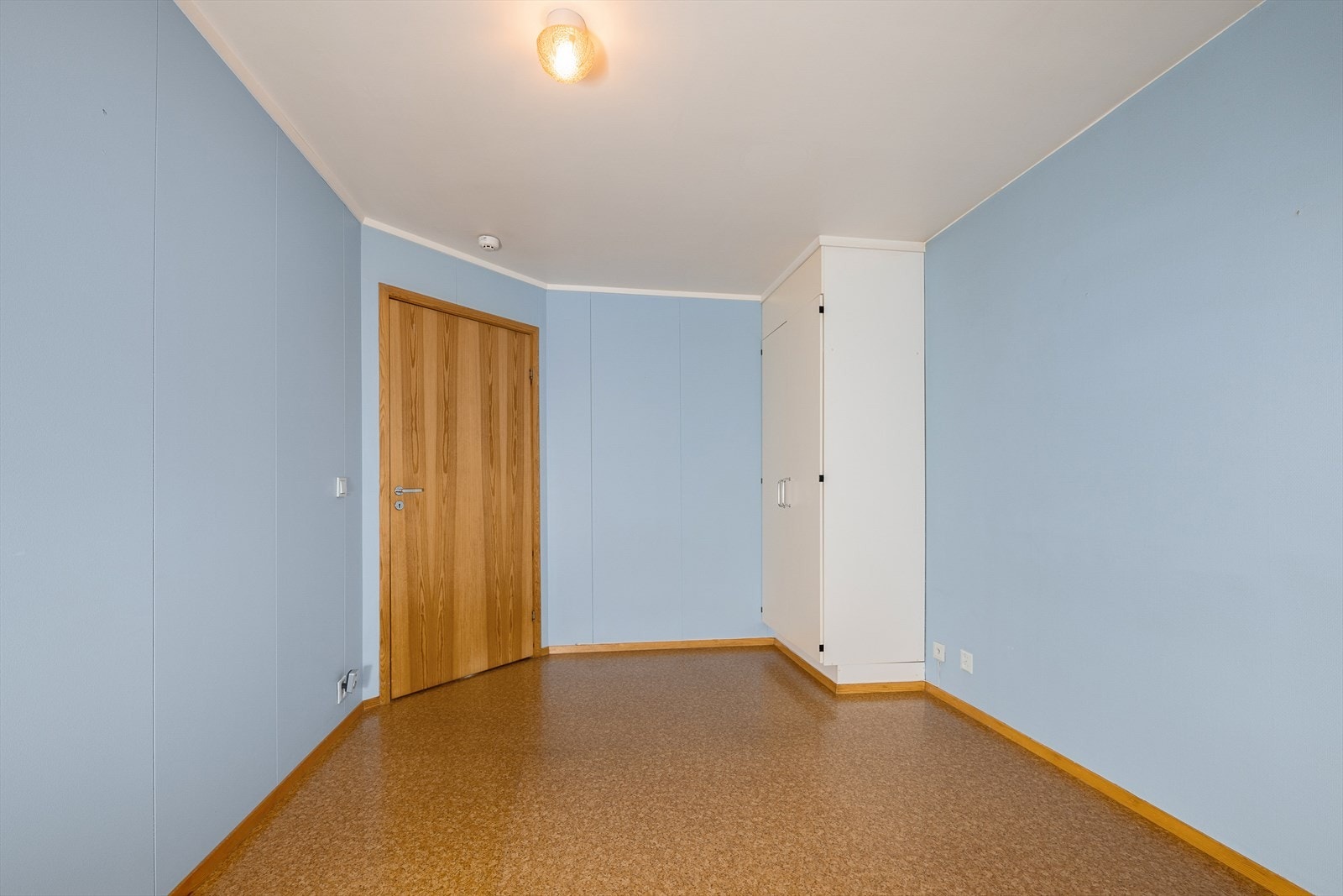 Soverommet har malte platevegger og glatte innerdører fra byggeåret. Galleribilde