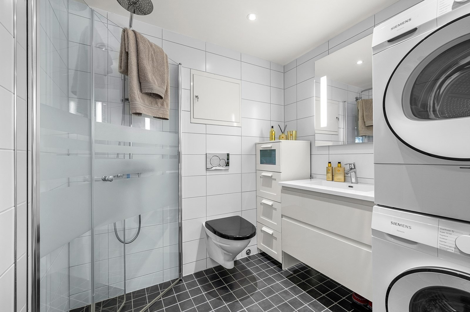 Flislagt bad med behagelig gulvvarme. Innredning er levert av HTH. Downlights i himling og opplegg for vask og tørk Galleribilde