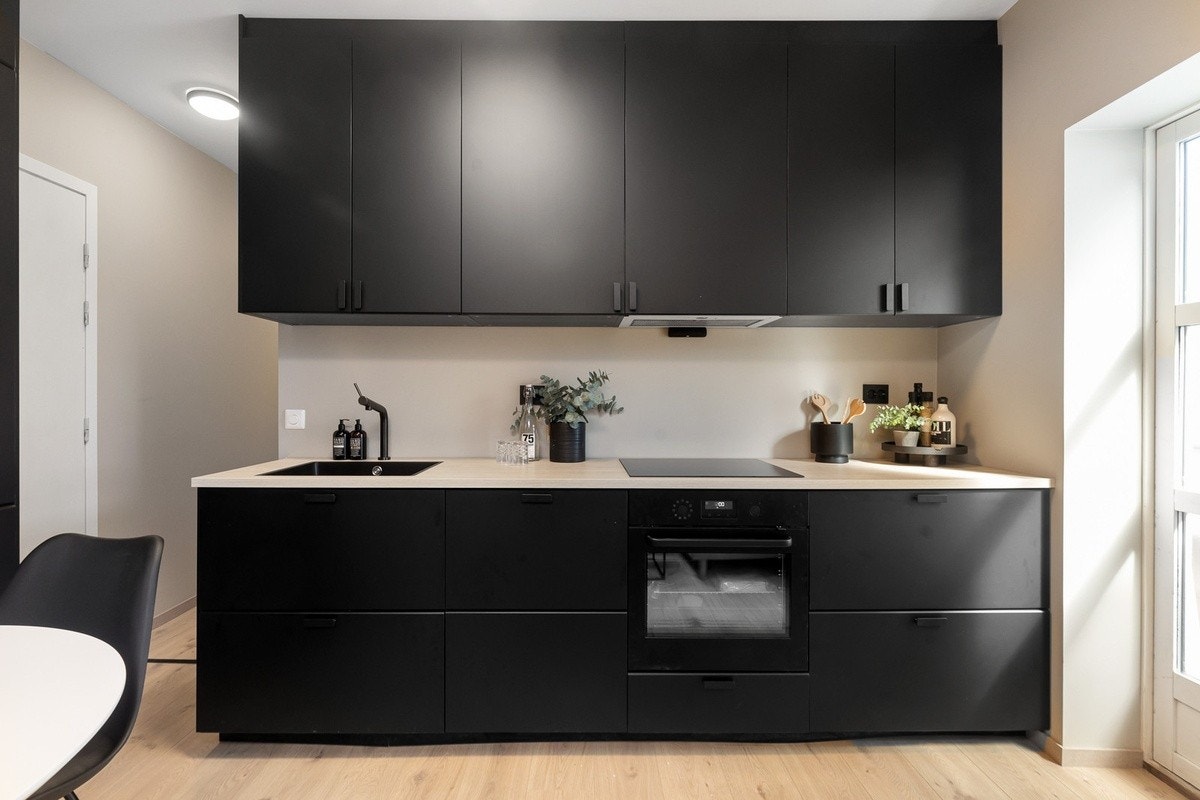 Nyoppusset kjøkken/stue med integrerte hvitevarer og møblert fellesareal Galleribilde