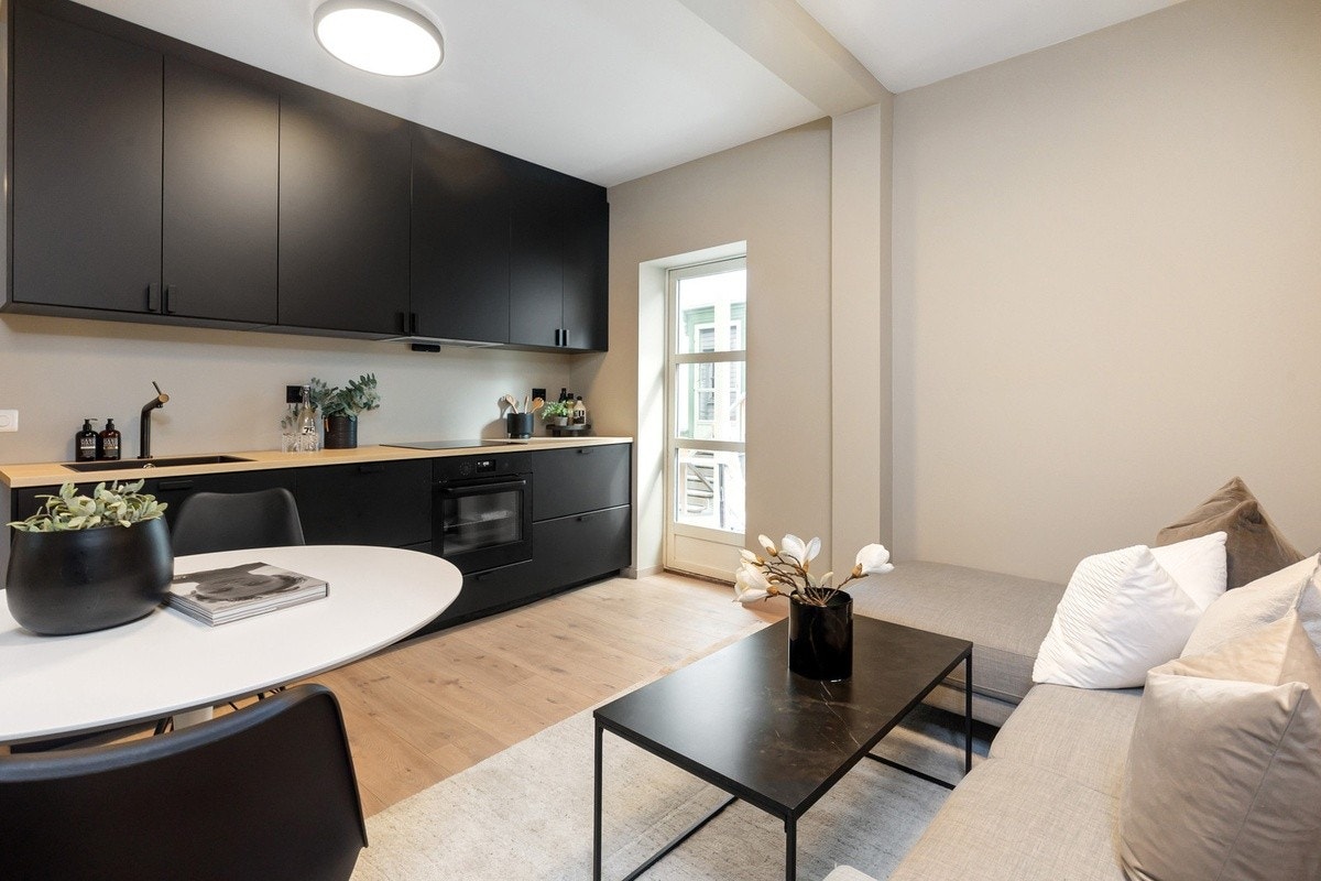 Nyoppusset kjøkken/stue med integrerte hvitevarer og møblert fellesareal Galleribilde