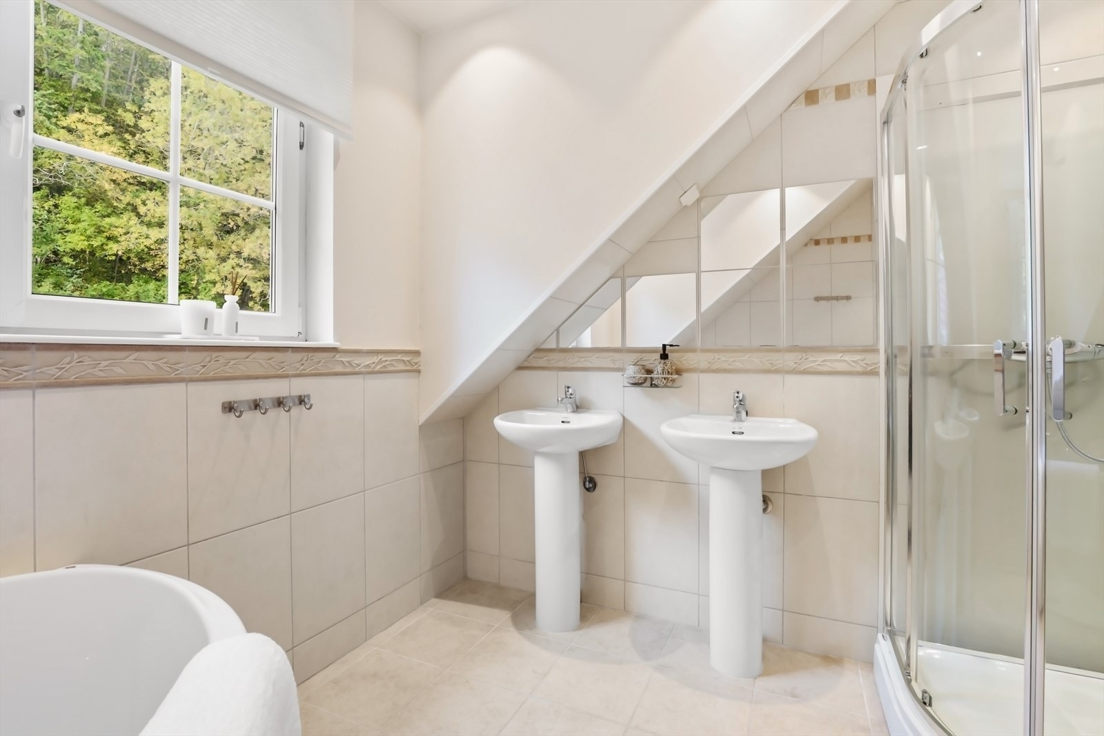 To søyleservanter, vegghengt toalett og hjørnebadekar. Galleribilde