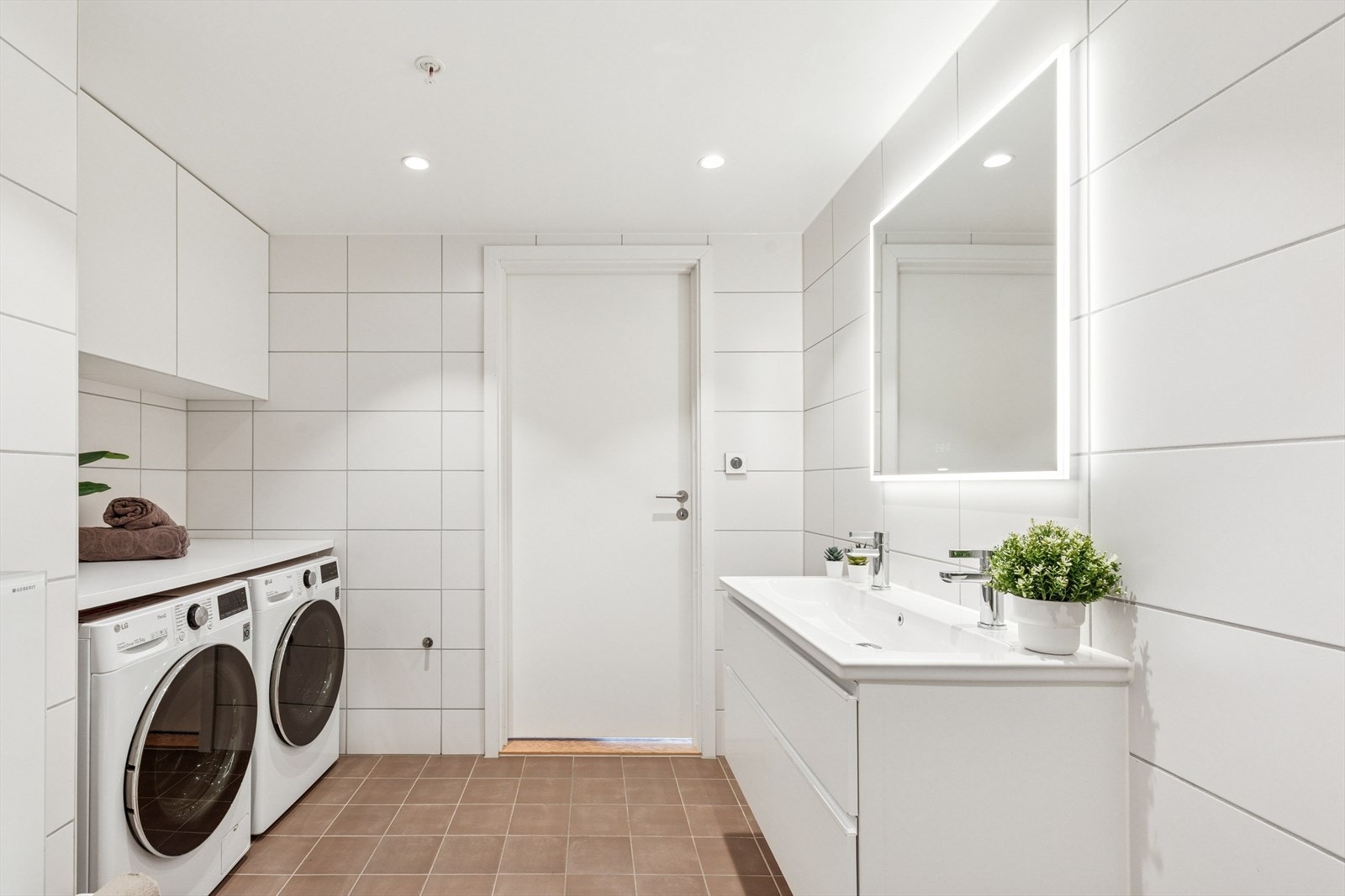 Badet har en praktisk vaskeromsdel med plass til vaskemaskin og tørketrommel, praktisk benkeplass og ekstra god skapplass. Galleribilde