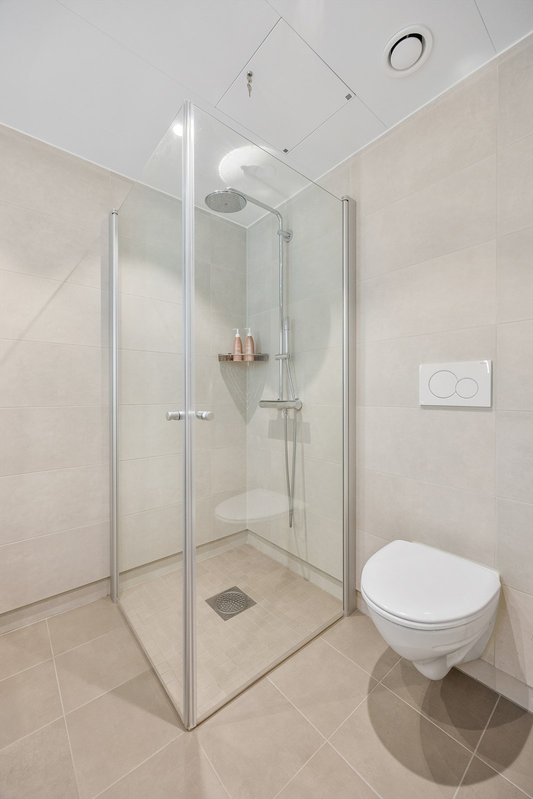 Dusjhjørne med innfellbare dører og vegghengt toalett for enkelt renhold. Galleribilde