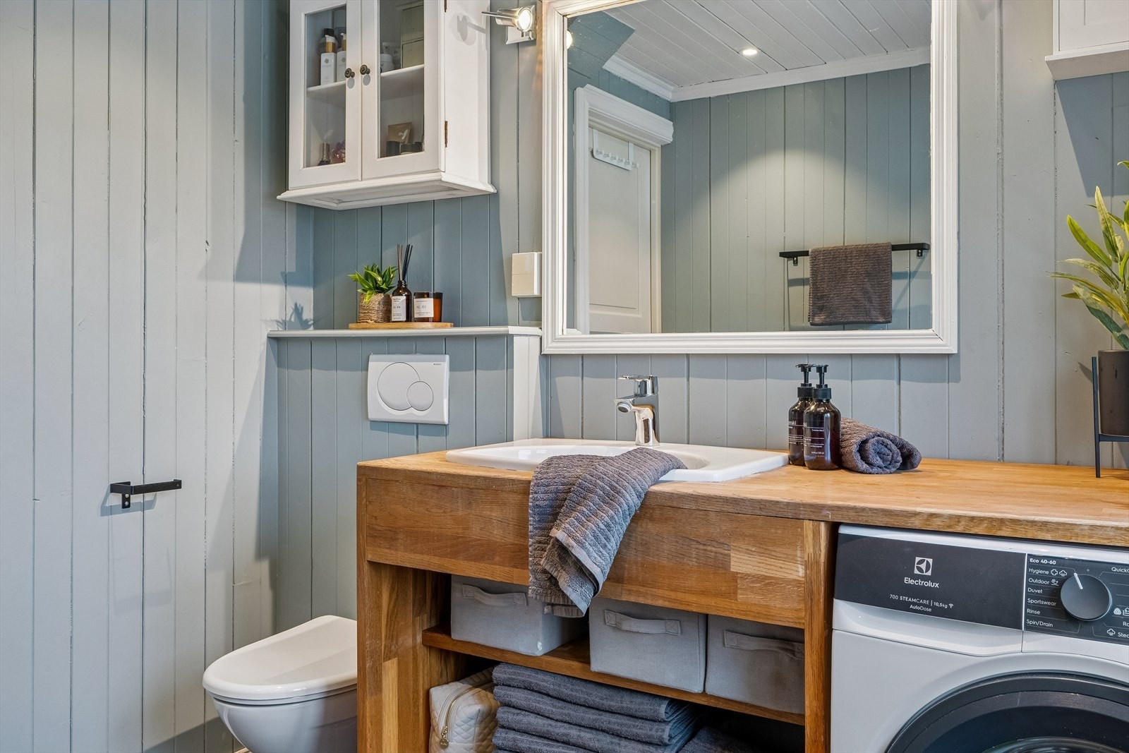 Bad med fliser på gulv og elektriske varmekabler. Vegger med fliser i dusjsonen og ellers malt trepanel. Galleribilde