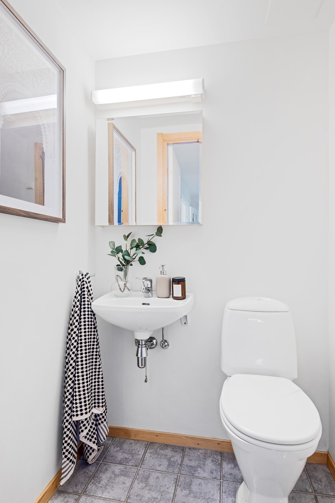 Toalettrom med flislagt gulv, elektriske varmekabler og malte veggflater. Innredet med toalett og vegghengt servant Galleribilde