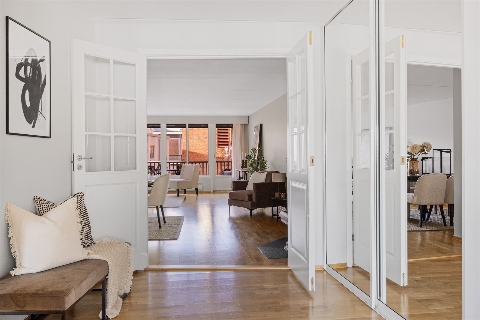 En to-fløyet glassdør inn til stuen gir et lyst og innbydende førsteinntrykk, samtidig som rommet enkelt kan lukkes av ved behov Galleribilde