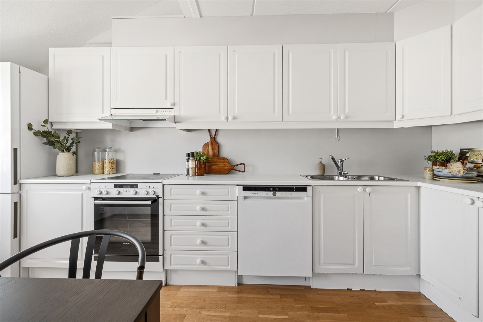 Kjøkkeninnredning med profilert sporfrest innredning og laminat benkeplate med dobbel, nedfelt stålkum Galleribilde