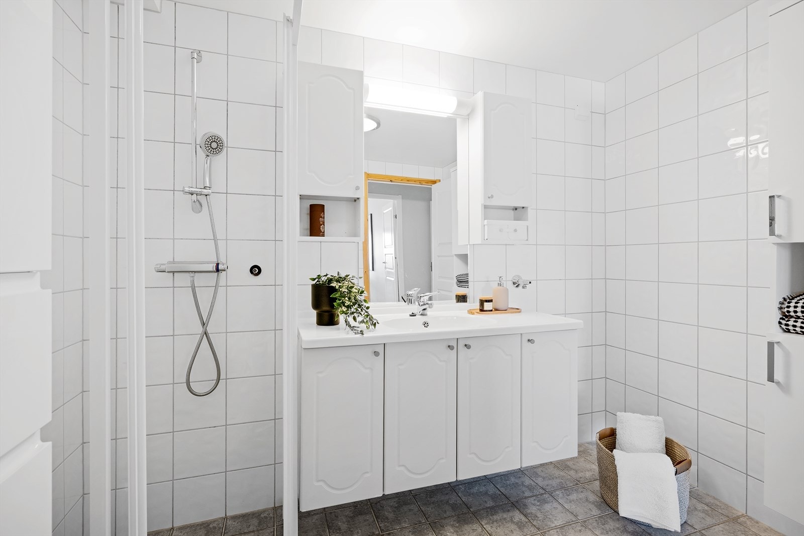 Innredet med toalett og dusjhjørne med skyvedører. Baderomsinnredning med gode oppbevaringsmuligheter, samt flere praktiske høyskap Galleribilde