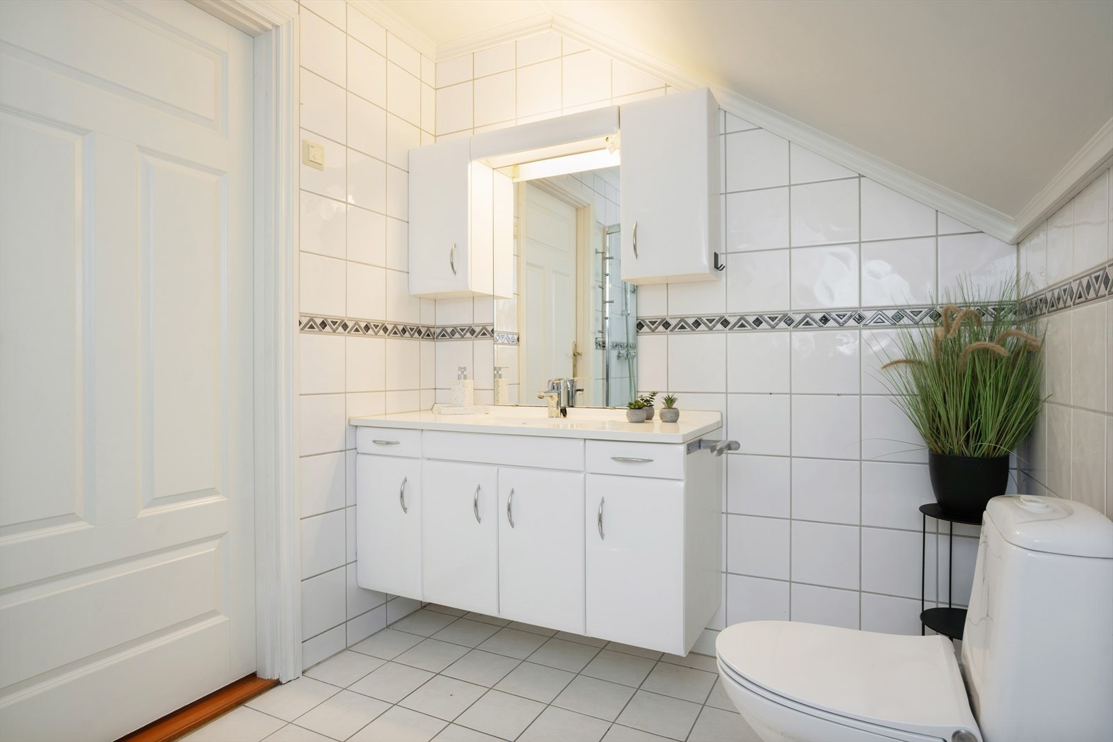 Badet er innredet med servant med innredning, dusjhjørne og gulvstående toalett. Galleribilde