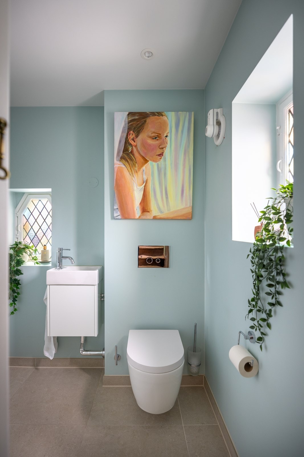 Praktisk toalettrom med vegghengt wc og servantskap samt opplegg for vaskemaskin/tørketrommel. Galleribilde