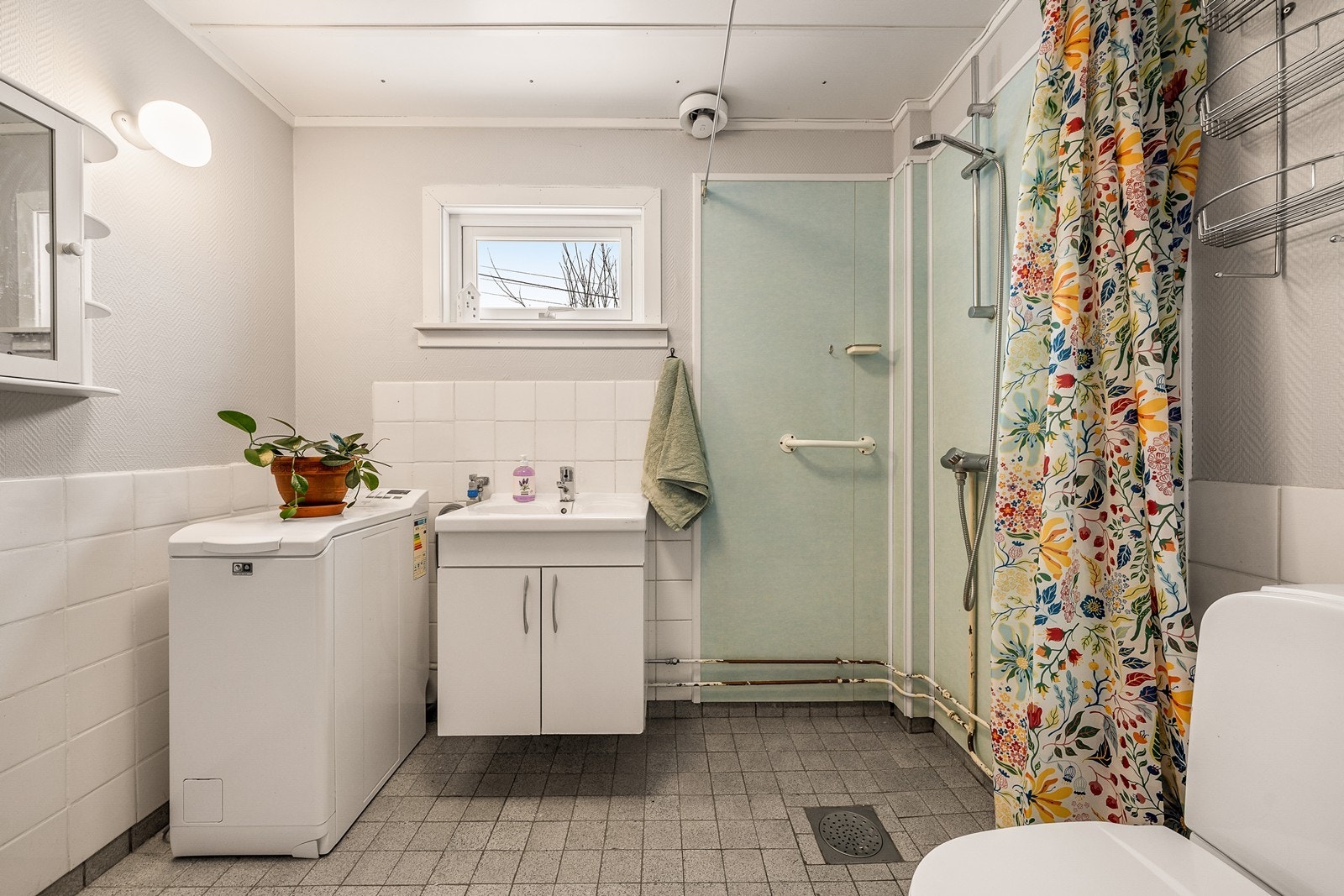 Bad har fliser på gulv og på vegg er det fliser og tapet. Galleribilde