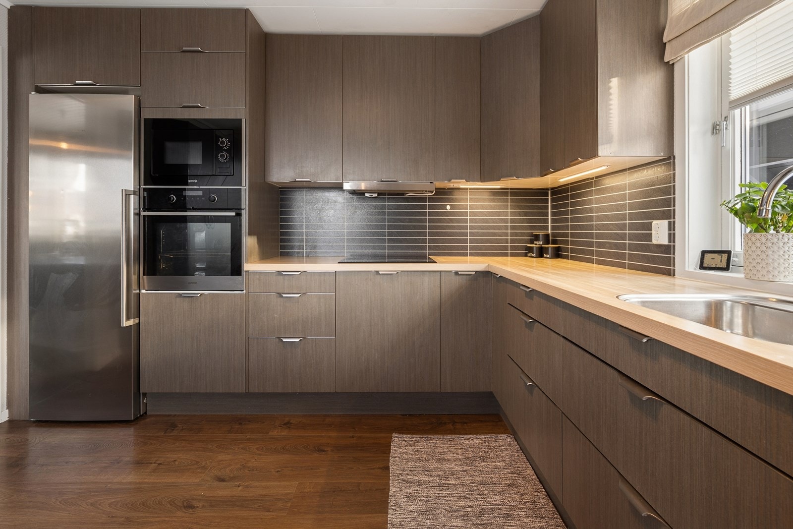 Kjøkkeninnredning med glatte fronter og laminat benkeplate Galleribilde