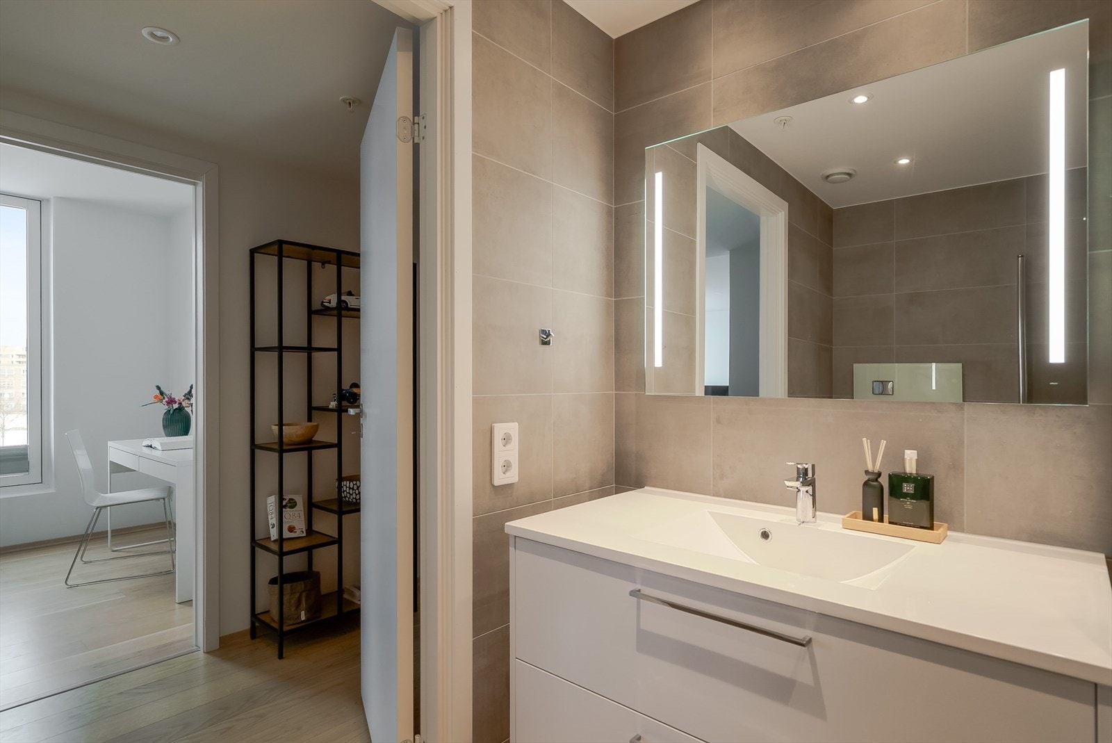 Romslig servantinnredning gir rikelig med oppbevaringsplass, og speil med integrert belysning gir et moderne preg. Galleribilde