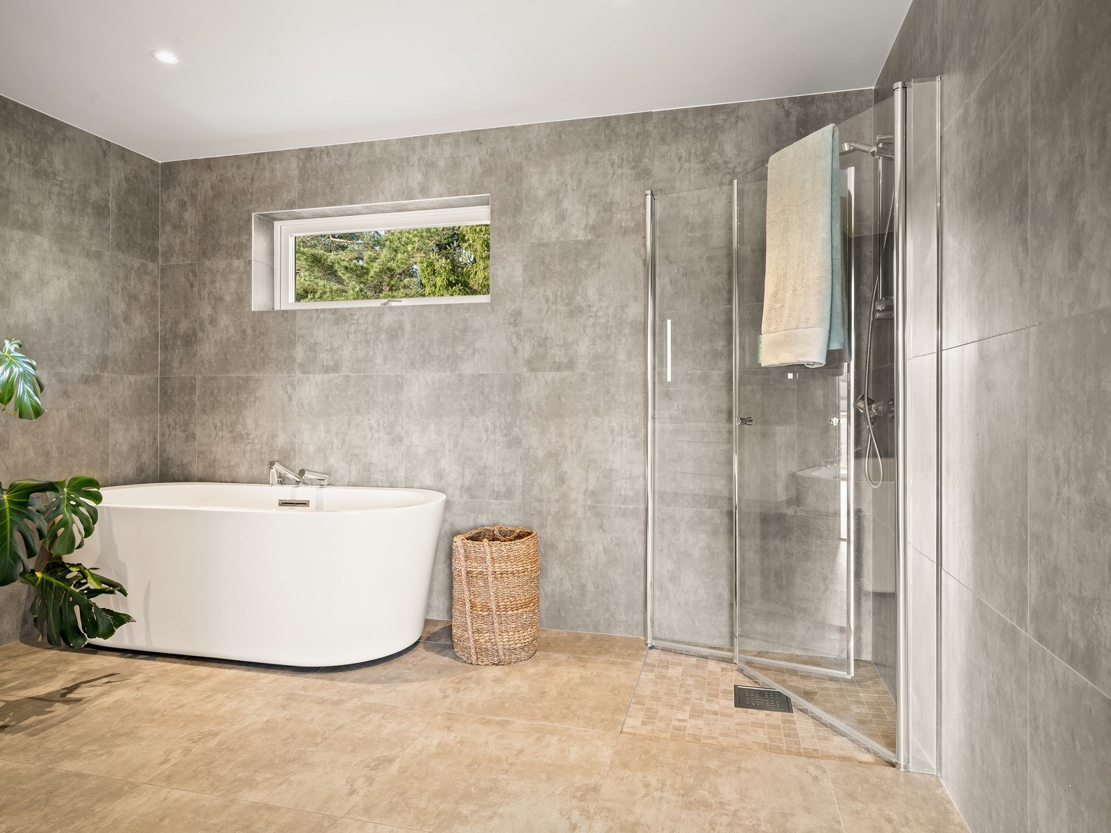 Flislagt baderom i 2.etasje er utstyrt med servantinnredning, vegghengt toalett, badekar og dusjhjørne med glassdører. Galleribilde