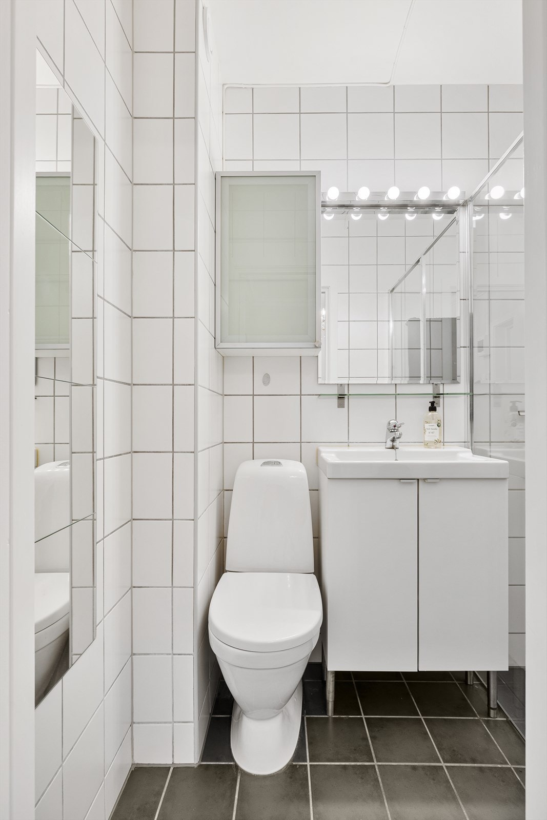 Innredet med WC, servantskap, speil og dusjdører. Vaskerom i kjeller. Galleribilde