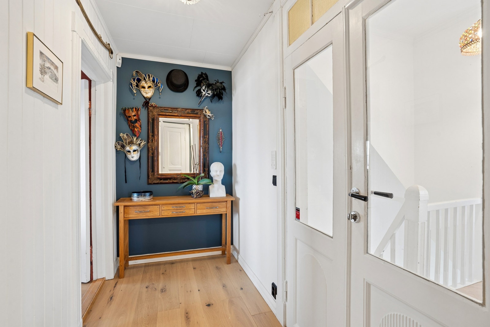 Entréen har parkett på gulvet og en original dør med glassfelt. Galleribilde