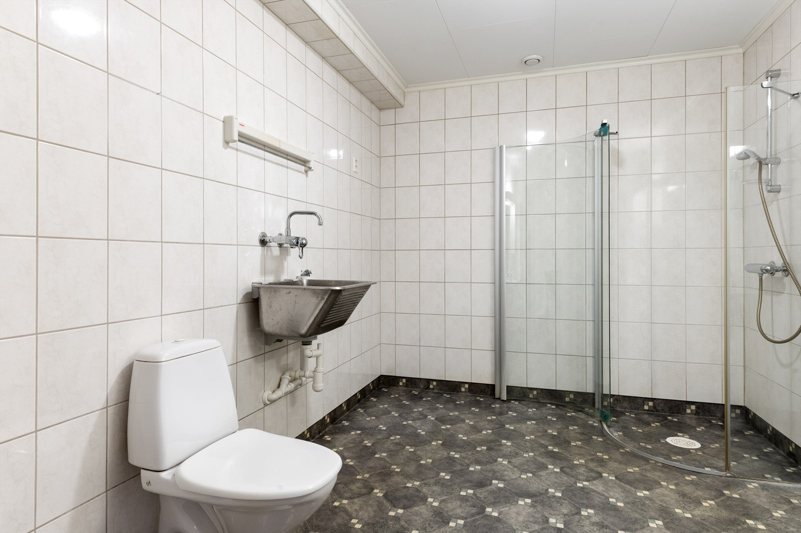 Badet er funksjonelt innredet med toalett, dusjhjørne og opplegg for vaskemaskin. Galleribilde