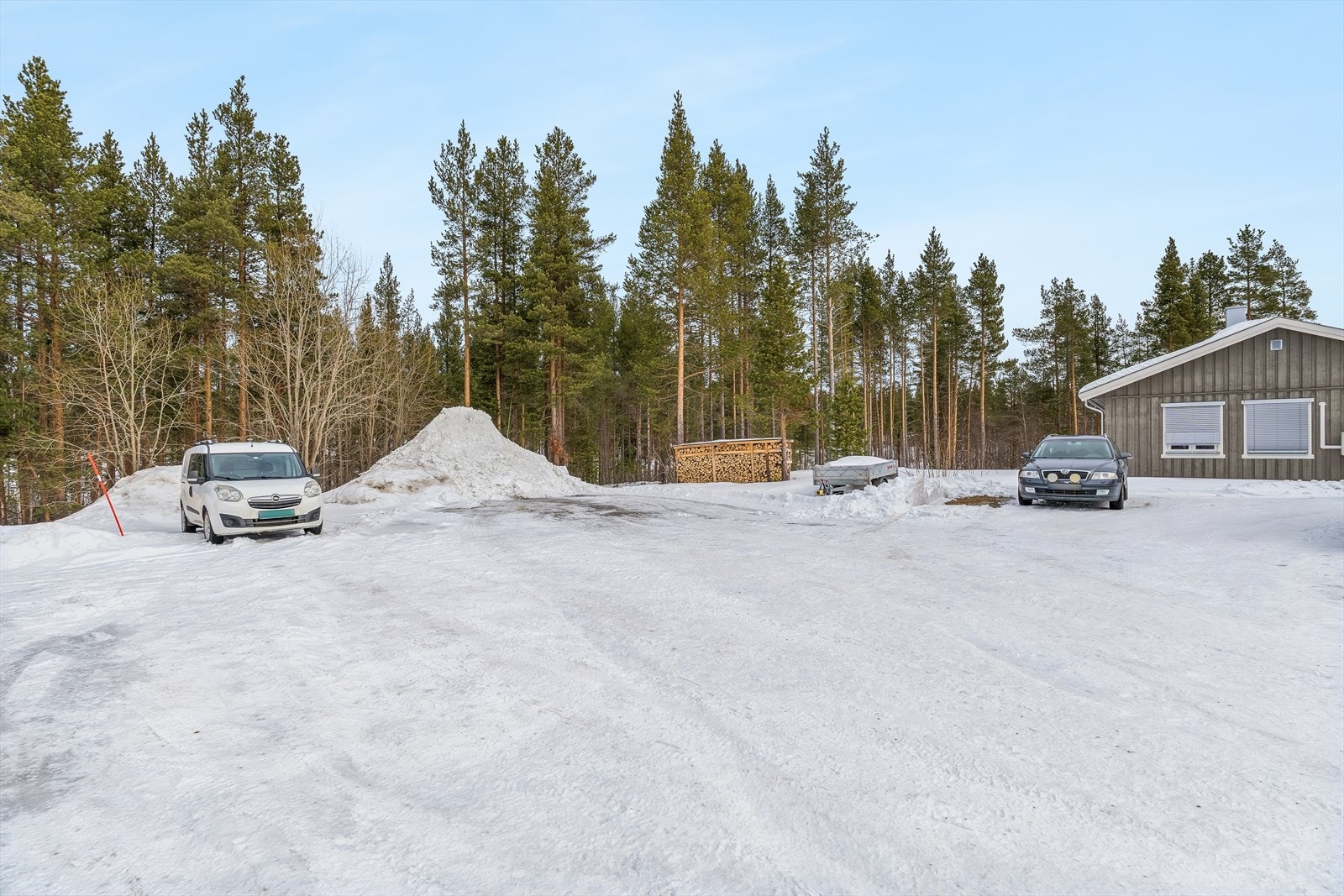 Stor, gruset gårdsplass med rikelig med parkeringsmuligheter for flere biler. Galleribilde