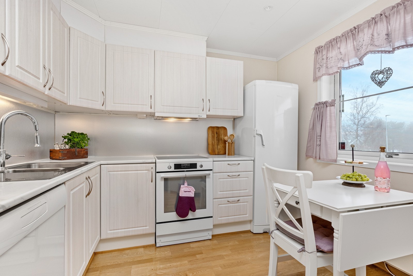 Kjøkkeninnredningen har profilerte fronter, og ble oppgradert med nye fronter, benkeplate, vask og kran i 2020. Galleribilde