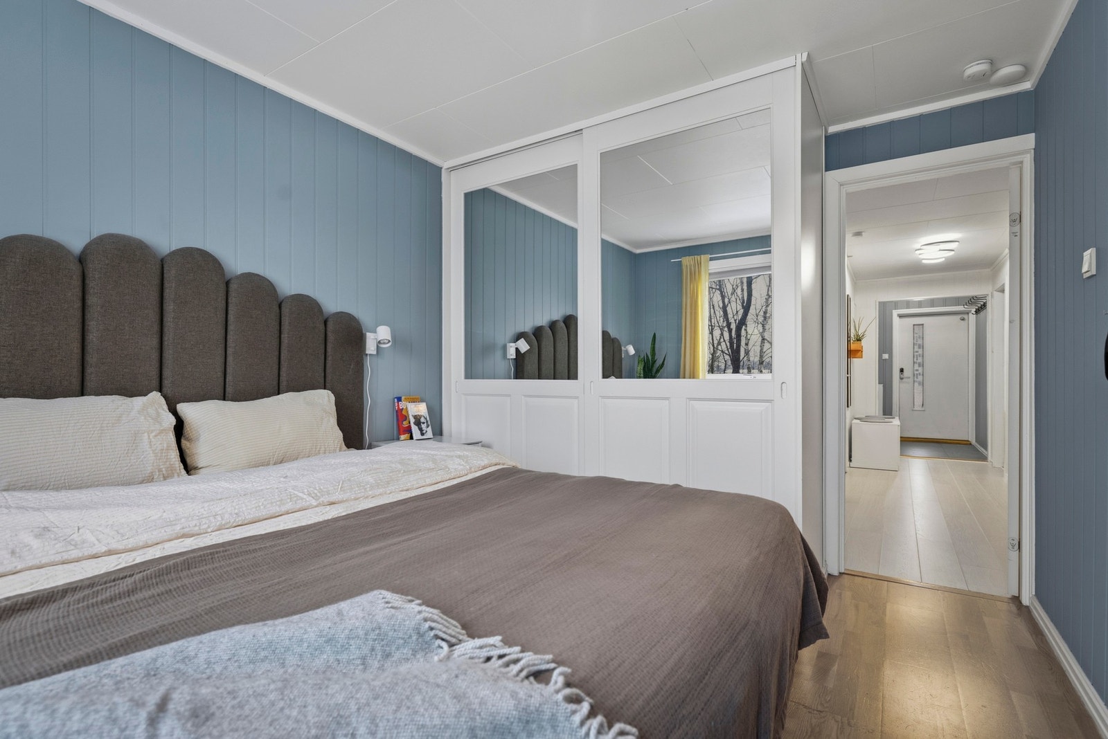 Rommet har utgang til en markterrasse og er innredet med garderobeskap som gir praktisk oppbevaringsplass for klær og sengetøy, og bidrar til et ryddig og organisert rom. Galleribilde