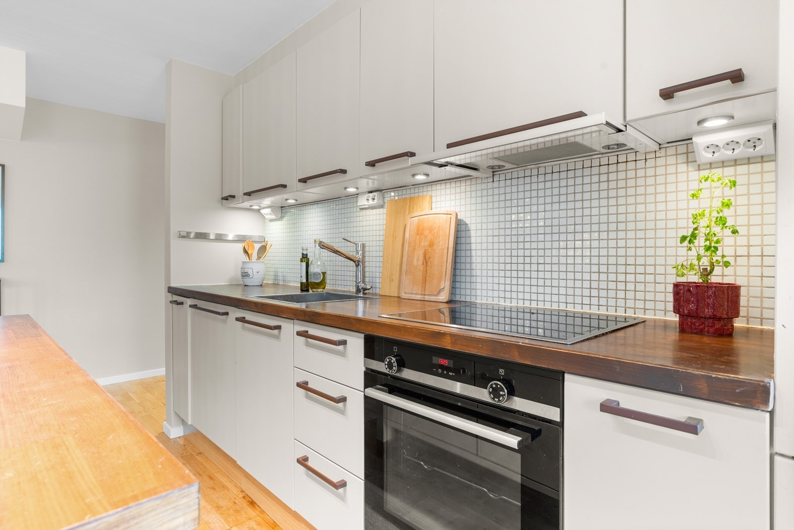 Kjøkkenet er utstyrt med integrerte hvitevarer, herunder platetopp, stekeovn, oppvaskmaskin samt kjøl- og fryseskap. Galleribilde