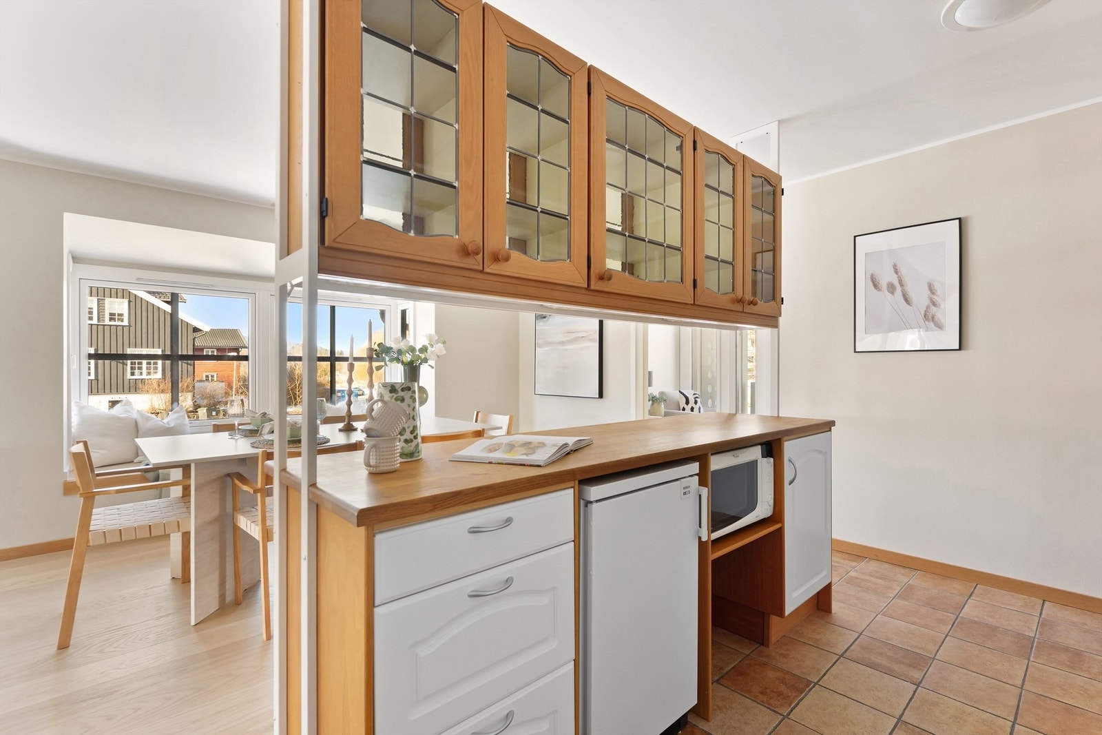 En praktisk kjøkkenøy med overskap i glass gir ekstra arbeids- og oppbevaringsplass. Galleribilde