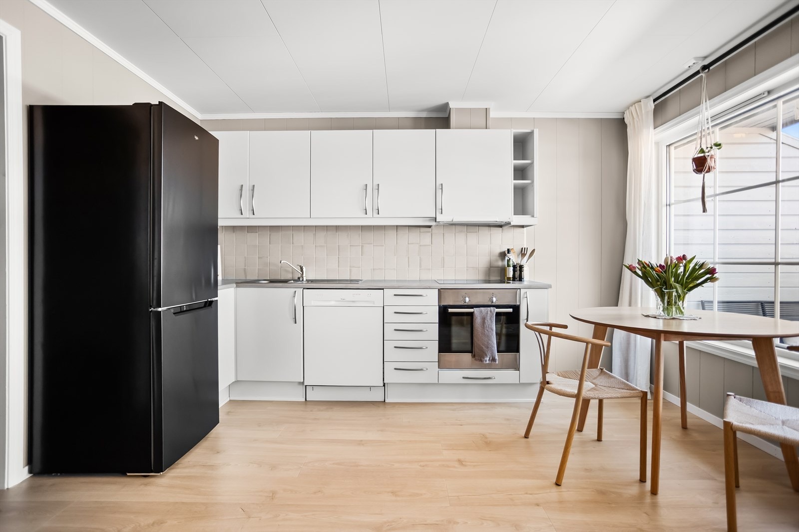 Kjøkkeninnredningen har hvite fronter og laminat benkeplate. Galleribilde