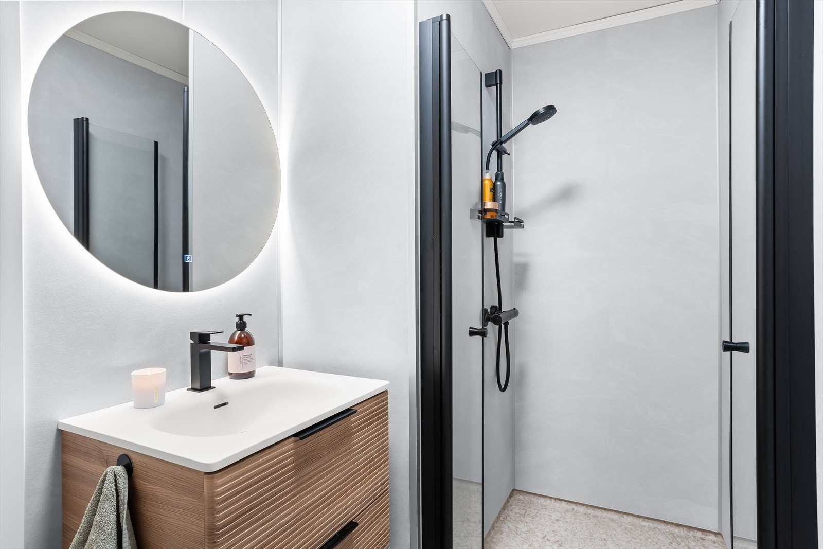 Badet har en finert servantinnredning, speil med lys og en dusjnisje med glassdører. Galleribilde