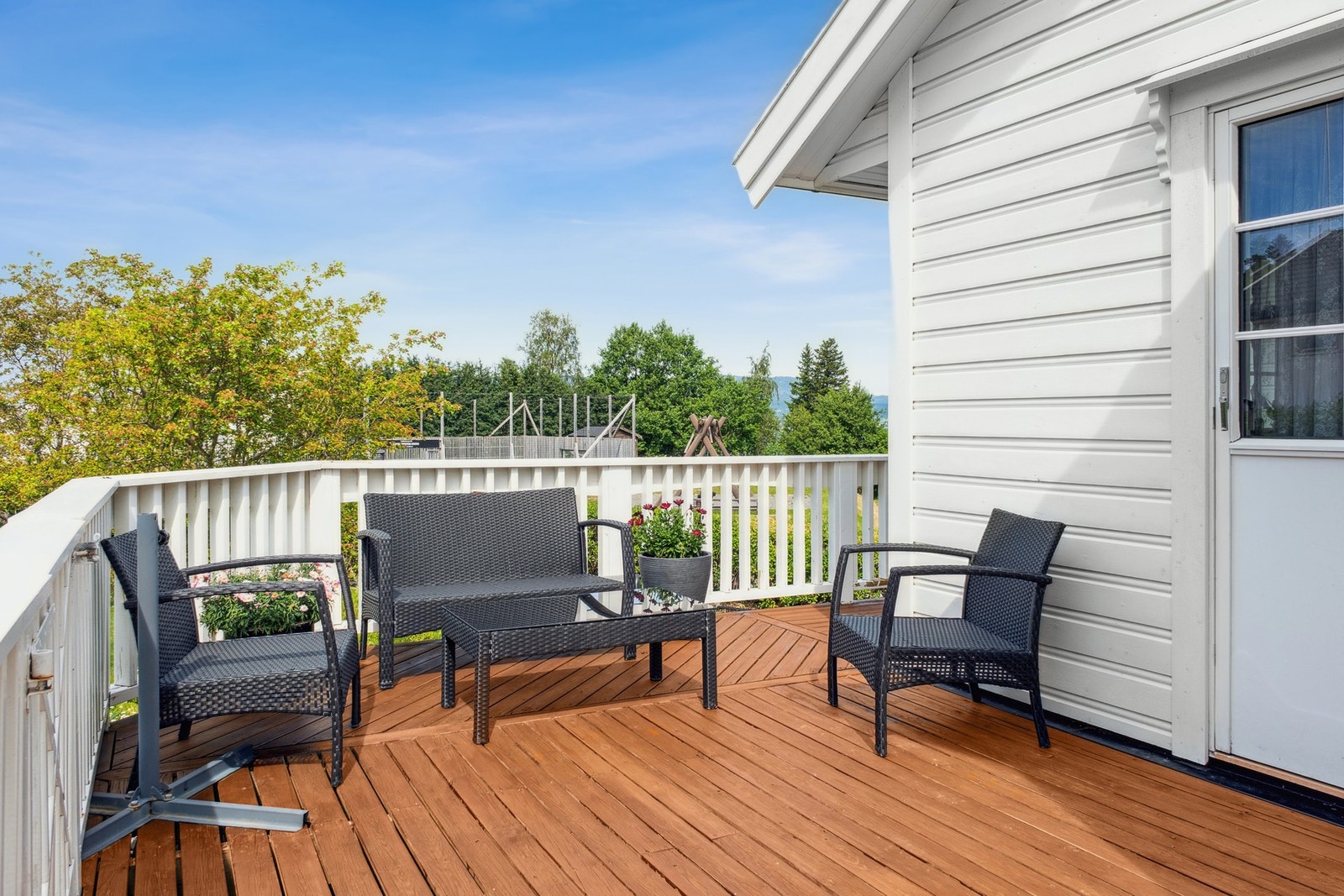 Stor veranda som strekker seg rundt boligen slik at man kan flytte seg etter sola Galleribilde