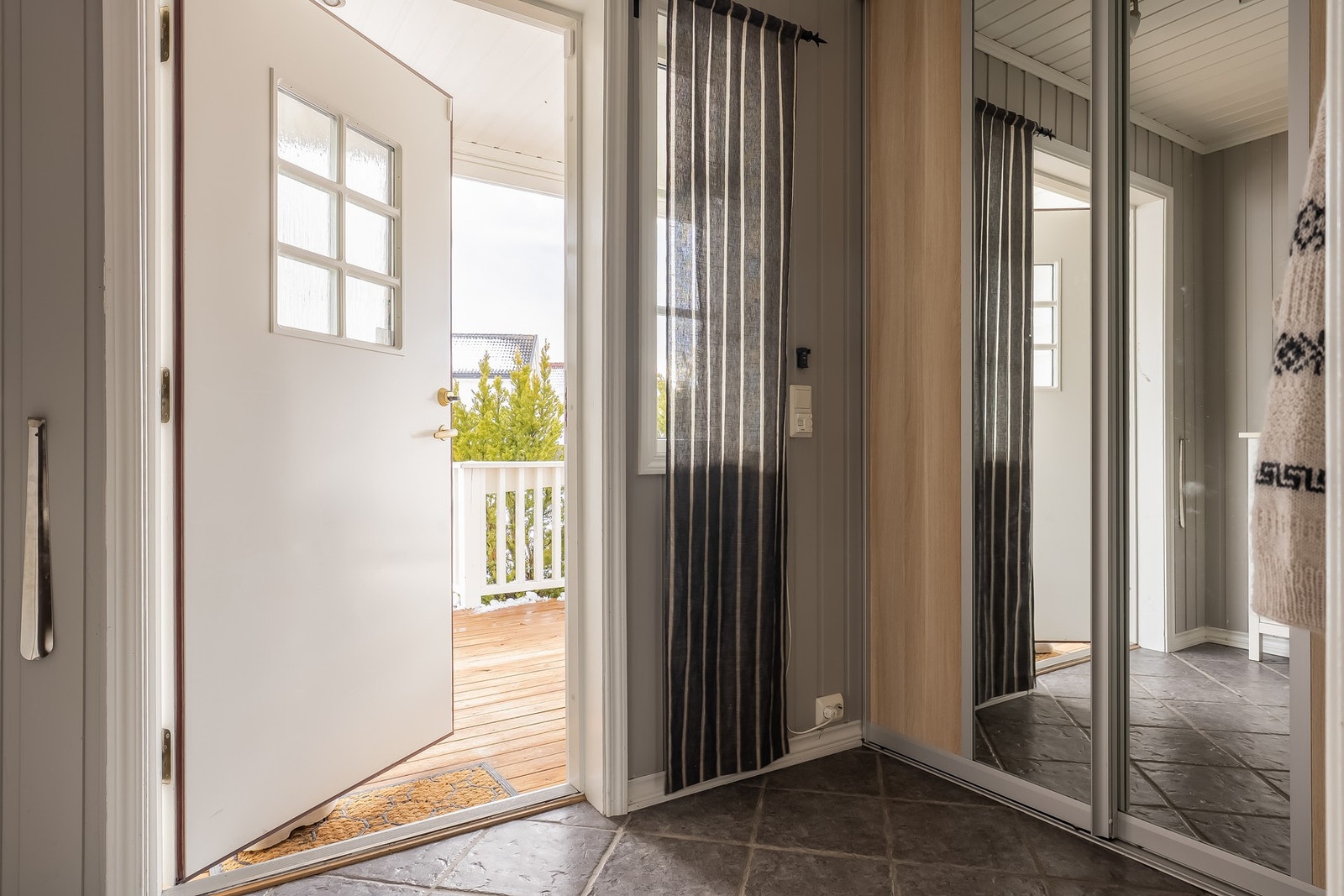 Lys og tiltalende entré med skyvedørsgarderobe og det er flislagt gulv med varmekabler Galleribilde