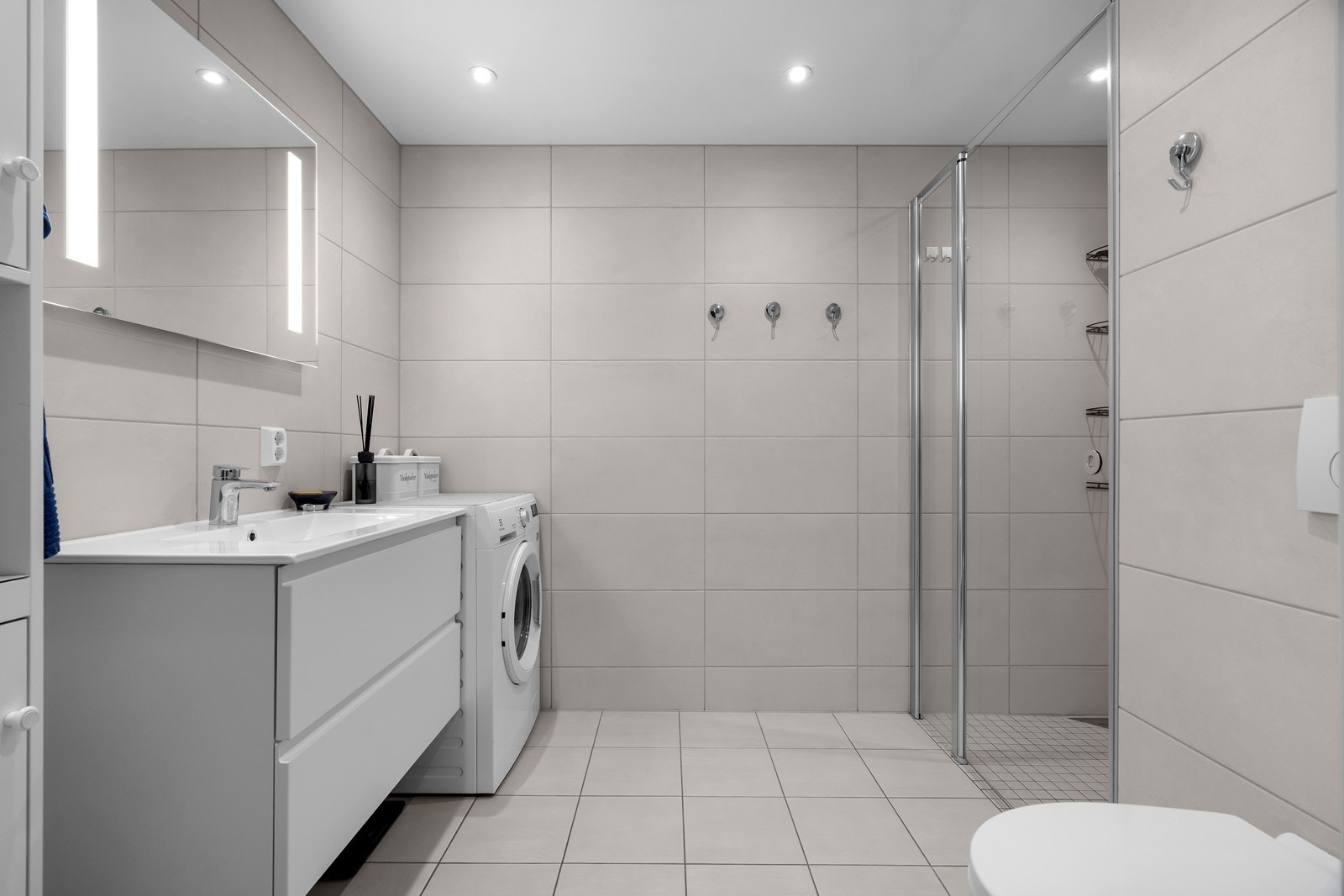 Fliselagt baderom med opplegg for vaskemaskin. Galleribilde