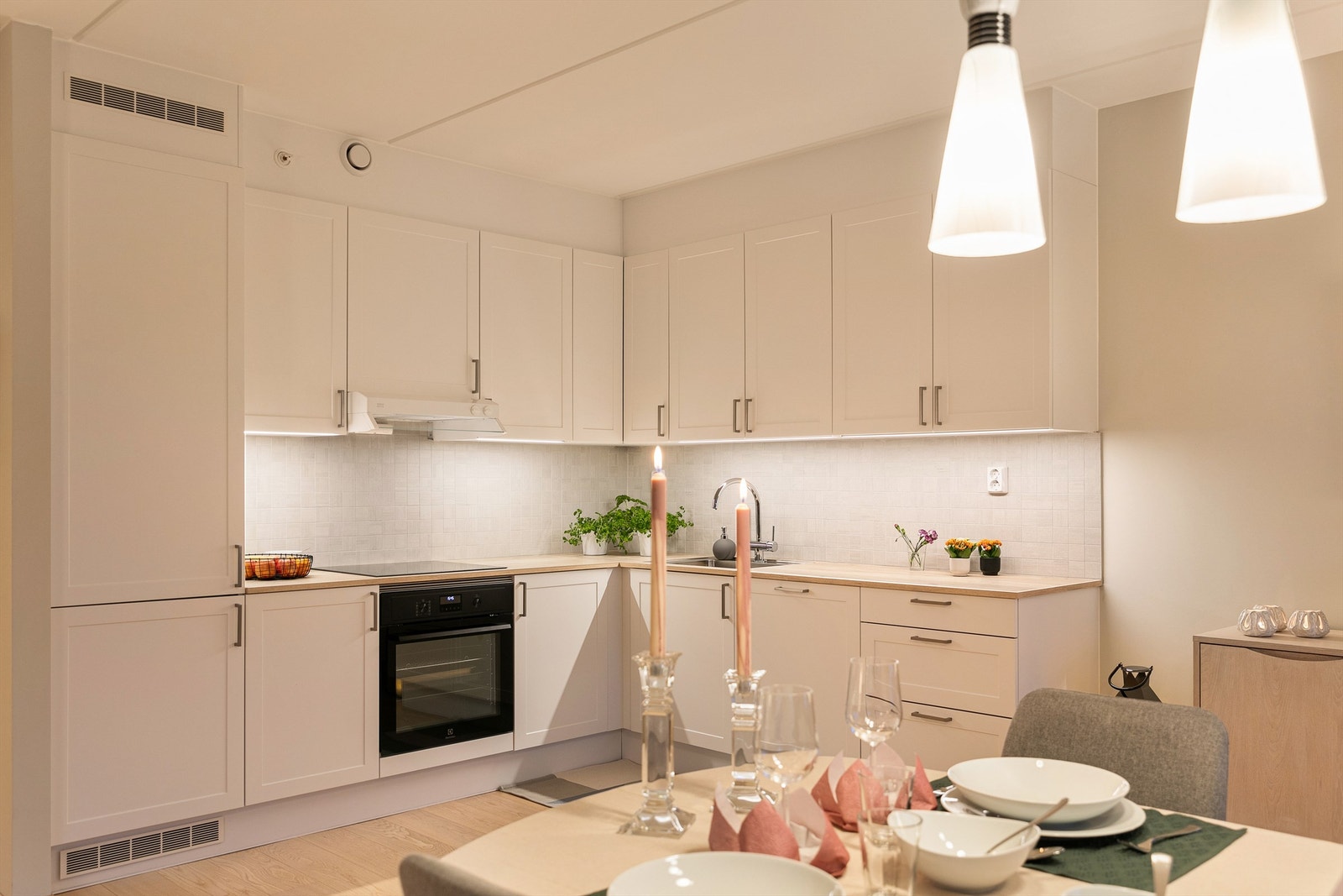 HTH Kjøkken med profilerte fronter fra 2023, laminatbenkeplate og planlimt oppvaskkum fra samme år. Fliser mellom benk og overskap samt praktiske stikkontakter over benken. Galleribilde