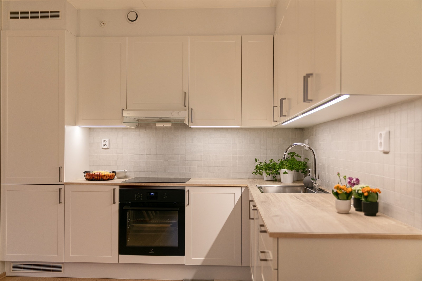 Integrerte hvitevarer. Kjøkkenventilator med mekanisk avtrekk plassert i overskap over platetopp. Sensor for lekkasjestopper er montert i kjøkkenbenk. Komfyrvakt montert over platetopp. Galleribilde