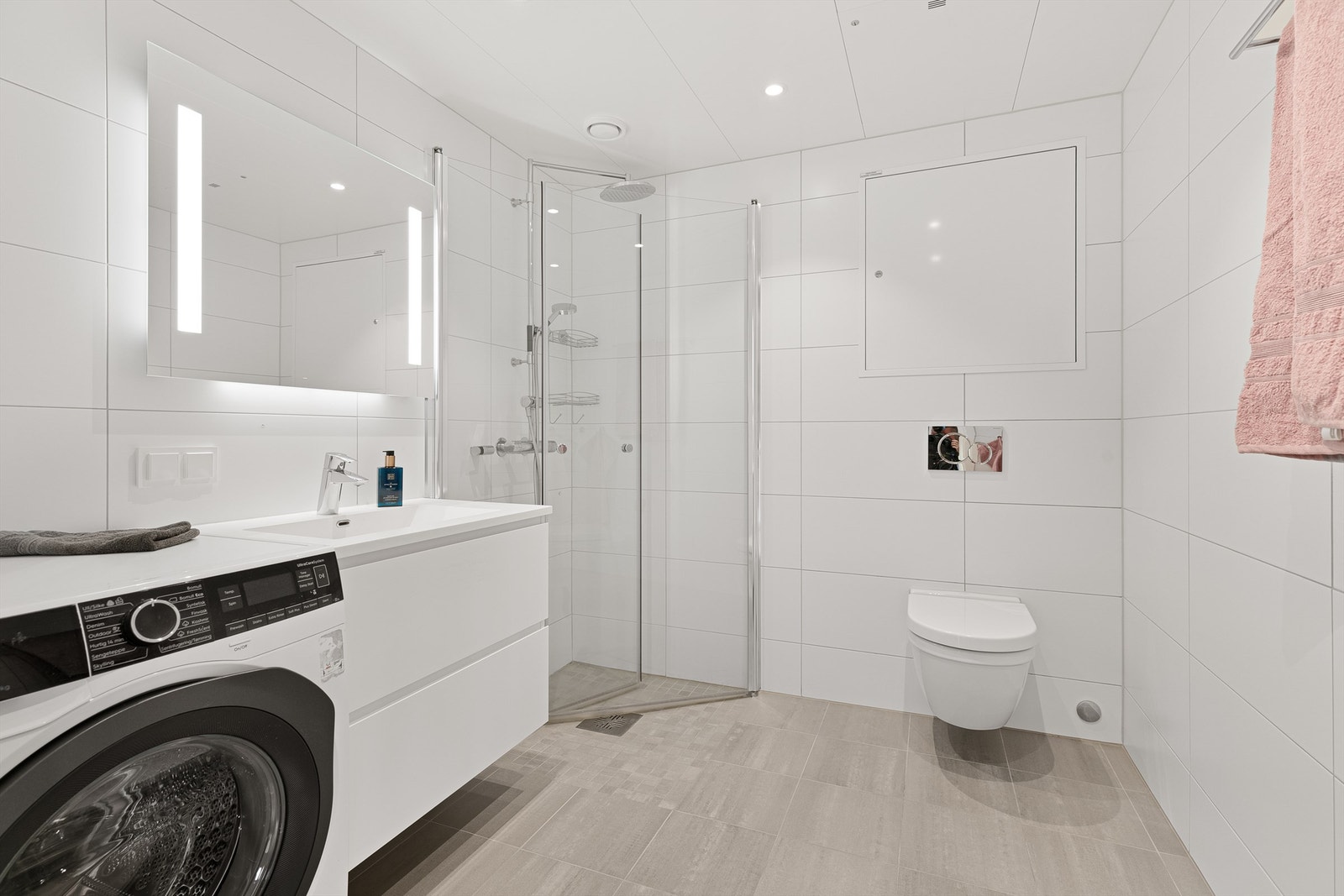 Baderom fra byggeår. Flislagt gulv med varme og flislagte vegger. Himlingsflate med hvite metallplater med downlights. Vegghengt servantskap
med glatte fronter. Heldekkende servant og vegghengt speil med integrert lys. Opplegg for vaskemaskin. Galleribilde