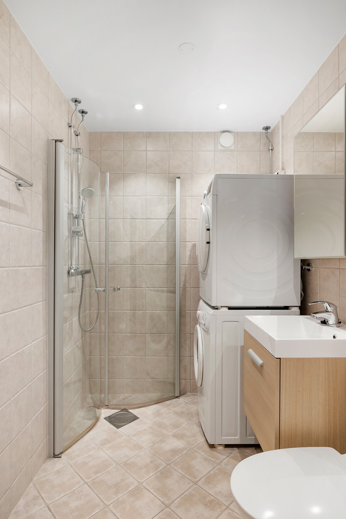 Badet består av inn- utadslående dusjvegger, servant m/underskap, overskap m/speilfront, toalett og opplegg for vaskemaskin. Galleribilde