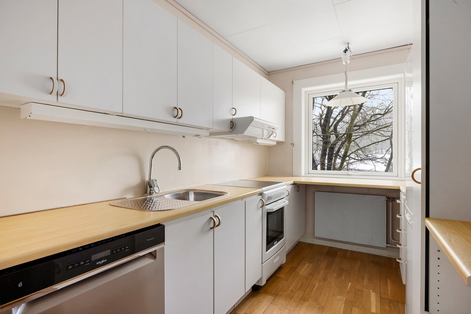 Kjøkkeninnredning med slette folierte fronter, laminat benkeplate, enkel oppvaskkum, ventilator og opplegg for oppvaskmaskin Galleribilde