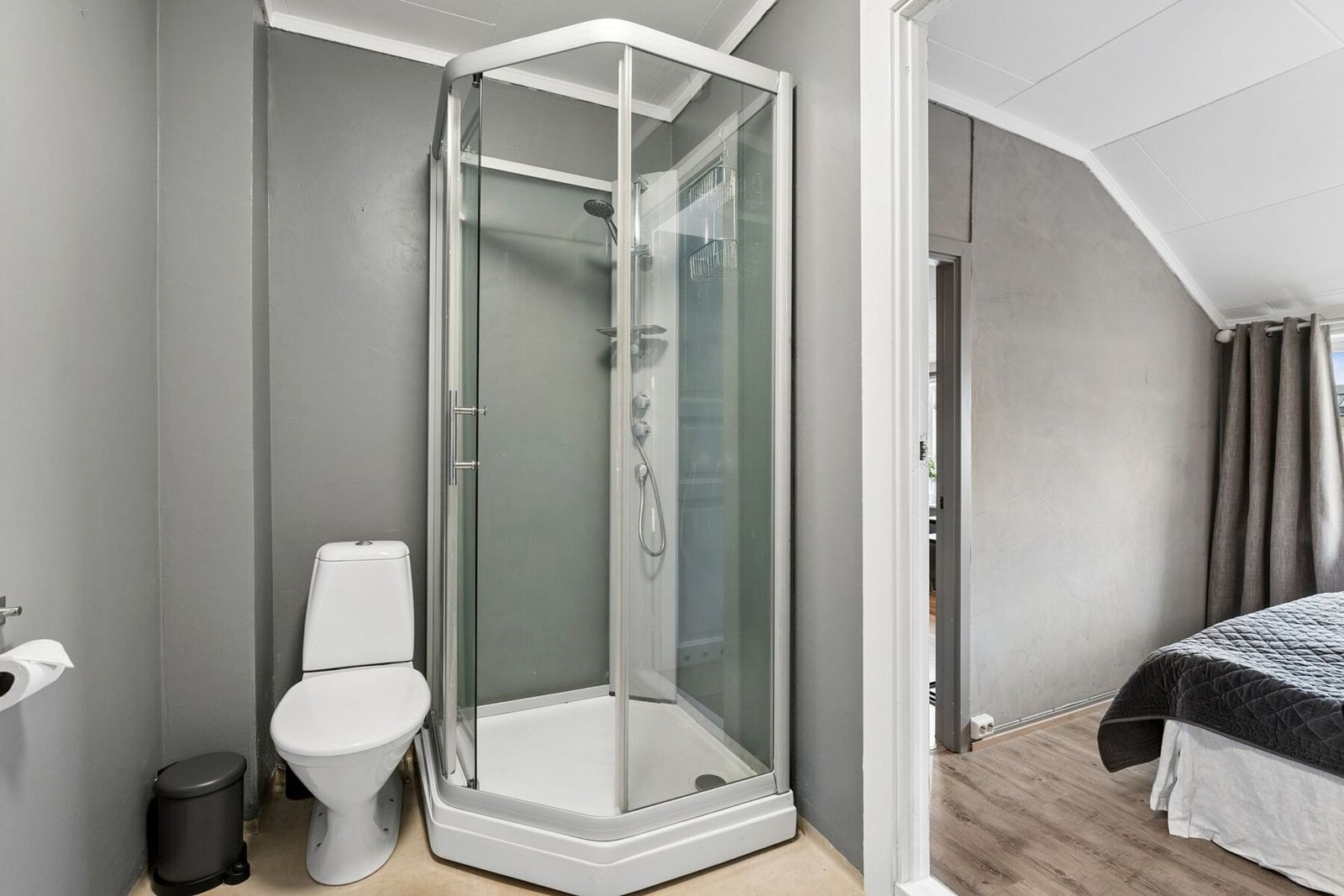 Praktisk bad utstyrt med dusjkabinett og toalett. Galleribilde