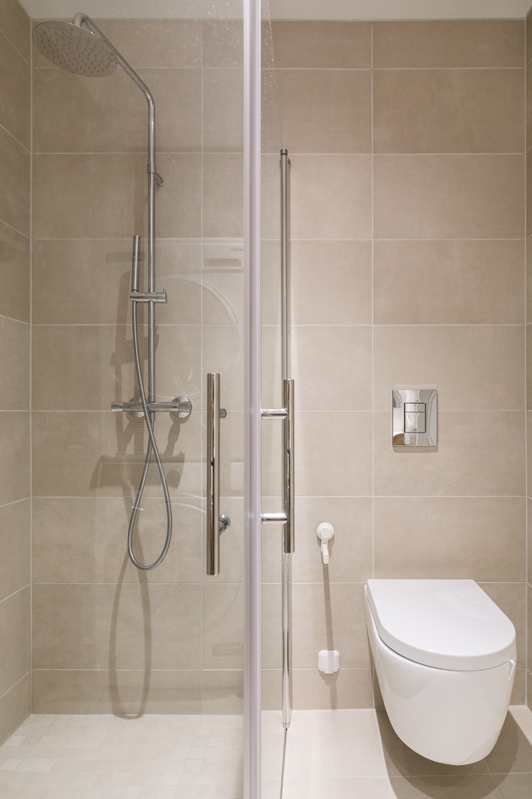 Badet har vegghengt toalett, samt dusjhjørne med innfellbare glassdører Galleribilde