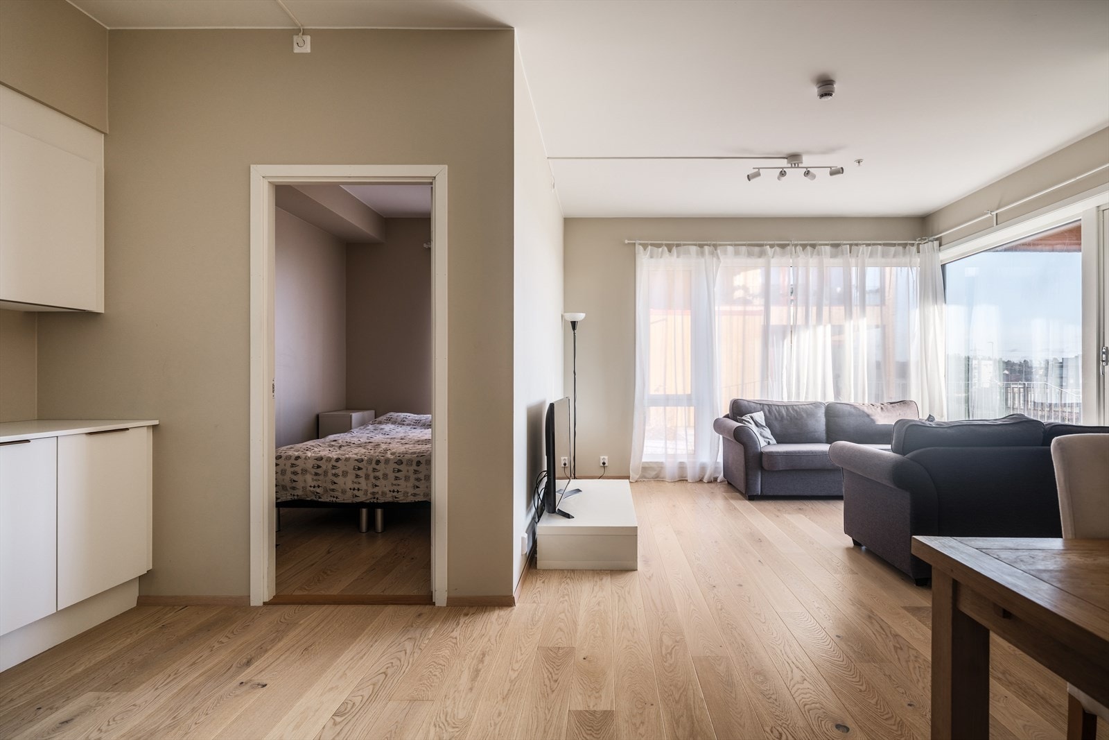 Lys og innbydende stue med moderne fargevalg på vegger og flott parkett på gulv Galleribilde