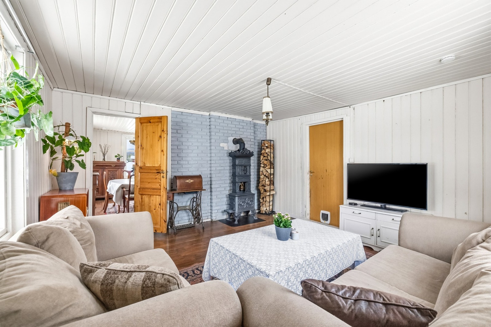 Stuen har plass til både sofagruppe og samlingspunkt for gode kvelder - og med vedovn i rommet ligger alt til rette for lun varme på kjølige dager. (Vedovnen medfølger ikke) Galleribilde