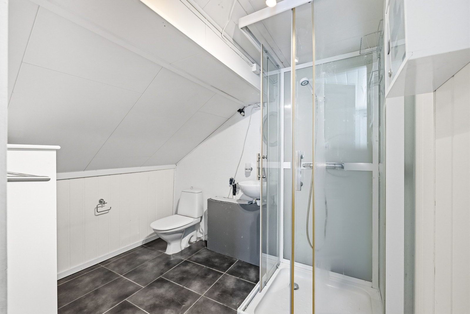 Baderommet i loftsetasjen består av dusjkabinett, servant og gulvstående toalett. Galleribilde