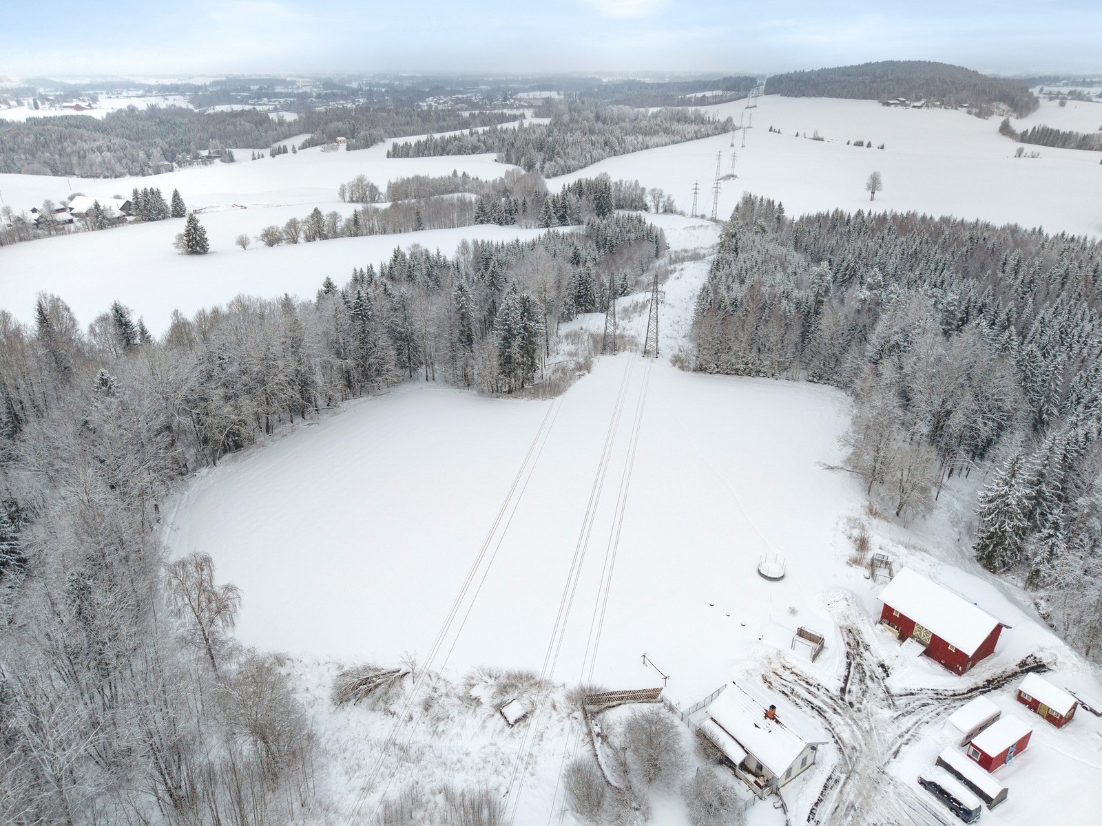 Dronebilde som viser hele tunet samlet - et hyggelig gårdsmiljø hvor bygningene danner et naturlig samlingspunkt. Galleribilde