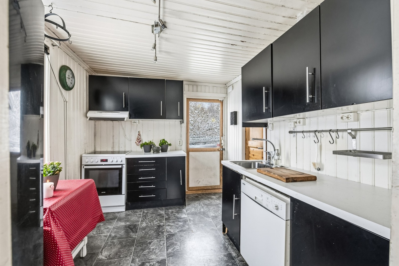 Kjøkkenet har en enkel og funksjonell utforming med innredning langs veggene. Her finnes både benkeplass, oppbevaring og plass til hvitevarer - og samtidig et tydelig potensial for den som ønsker å modernisere etter egen smak. Galleribilde